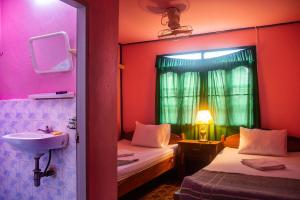 a room with two beds and a sink and a window at Xaymountry Don Khon City Center Residence and Guesthouse in Ban Donsôm