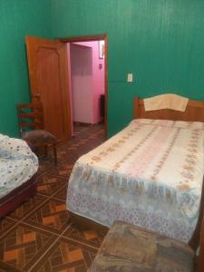 um quarto com 2 camas e uma parede verde em Hermoso Departamento todas las comodidades WiFi em Tuxtla Gutiérrez
