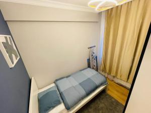 a small bed in a small room with a window at Private Apt, 2 mins to Transp. in Istanbul
