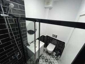 a black and white bathroom with a toilet and a sink at Private Apt, 2 mins to Transp. in Istanbul