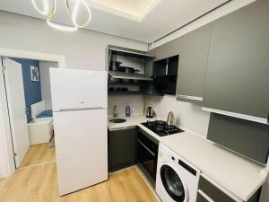 a kitchen with a white refrigerator and a washing machine at Private Apt, 2 mins to Transp. in Istanbul