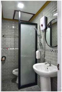 uma casa de banho com um lavatório, um espelho e um WC. em Riverside Chiangkhan em Ban Mai Ta Saeng