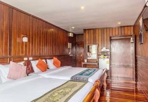 a bedroom with a large bed with wooden walls at Riverside Chiangkhan in Ban Mai Ta Saeng