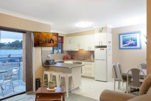 a kitchen and living room with a table and chairs at Apollo Unit 7 1st Floor in Narooma
