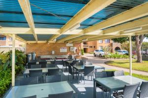 a patio with tables and chairs and a building at Apollo Unit 7 1st Floor in Narooma