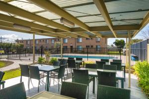 a patio with tables and chairs and a pool at Apollo Unit 7 1st Floor in Narooma