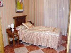 a bedroom with a small bed and a night stand at Vivienda Principal Torre de Campos in Ainzón +19 photos
