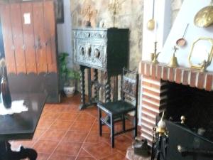 a living room with a fireplace and a chair at Vivienda Principal Torre de Campos in Ainzón