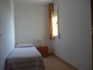 a small bedroom with a bed and a window at JOYAPARTMENTS La Joya in Miami Platja