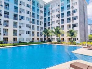 a swimming pool in front of a large apartment building at Davao City Condo Living Made Easy Lifestyle in Davao City