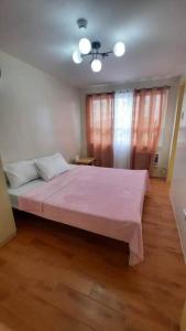 a bedroom with a large bed with pink sheets at Davao City Condo Living Made Easy Lifestyle in Davao City