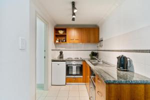 a kitchen with wooden cabinets and a counter top at Perth City Retreat - parking, pool, self contained in Perth