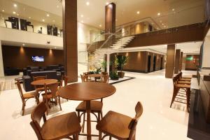 a restaurant with tables and chairs in a building at Hotel Caiuá Cascavel in Cascavel