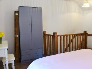 a bedroom with a blue cabinet next to a bed at Nant Y Felin in Llanfairfechan