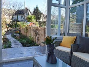 a screened in porch with a view of a garden at Nant Y Felin in Llanfairfechan