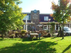 a building with a picnic table in the grass at Hotel and Restaurant van Saaze - Free Parking in Kraggenburg