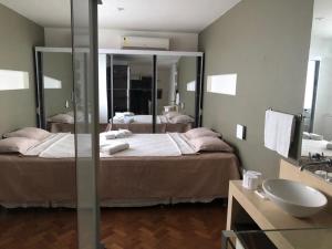 Schlafzimmer mit einem Bett, einem Spiegel und einem Waschbecken in der Unterkunft Duplex Ipanema Vinícius de Moraes in Rio de Janeiro
