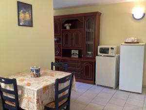 cocina con mesa y nevera blanca en Maison 4 pers proche chatelaillon plage, 