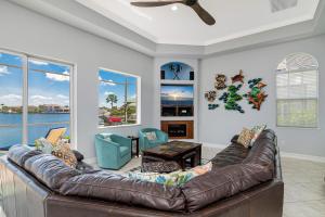 a living room with a brown leather couch at Waterfront home with pool, spa and 2nd floor balcony in Marco Island