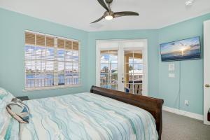 a bedroom with a bed and a ceiling fan at Waterfront home with pool, spa and 2nd floor balcony in Marco Island +49 photos