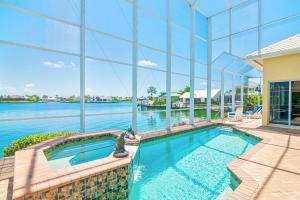 an indoor swimming pool with a view of the water at Waterfront home with pool, spa and 2nd floor balcony in Marco Island