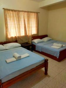 Dos camas en una habitación con toallas. en OYO 931 Moreno's Place, en Boracay