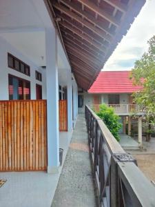 a walkway leading to a building with a wooden roof at LilyPad guest house in Kuta Lombok