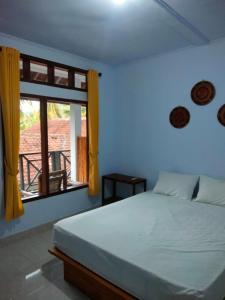 a bedroom with a bed and a window at LilyPad guest house in Kuta Lombok