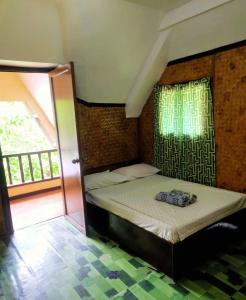 OYO 931 Moreno's Lodging Boracay في بوراكاي: غرفة نوم بسرير مع مظلة ونافذة