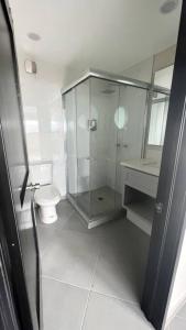 y baño con ducha de cristal y aseo. en Luxury 2BR Condo Rosarito (G) en Rosarito