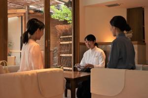 three women sitting around a table in a room at Monjusou in Miyazu