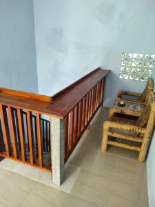 escalera de madera en una habitación con silla en LilyPad guest house en Kuta Lombok