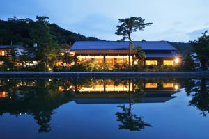 a house with a reflection in the water at night at Monjusou in Miyazu