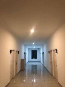 an empty hallway with doors and a stage in a building at Damai Guest House Cirebon in Cirebon
