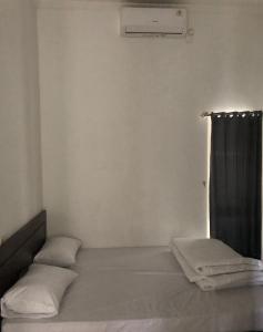 a bedroom with a bed with a black curtain at Damai Guest House Cirebon in Cirebon