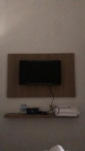 TV de pantalla plana en un estante de una habitación en Damai Guest House Cirebon, en Cirebon