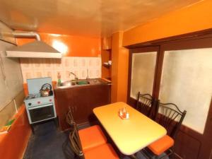 cocina pequeña con mesa amarilla y fogones en Departamento Independiente Carnaval Oruro 2023, en Oruro