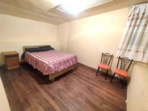 1 dormitorio con 1 cama y 2 sillas en Departamento Independiente Carnaval Oruro 2023, en Oruro