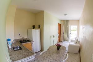une cuisine avec un réfrigérateur blanc dans une pièce dans l'établissement Apartamentos Praia Campeche 50m do mar, à Florianópolis 32 autres photos