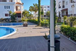 a courtyard with a swimming pool and a building at Résidence Costa Cabo in Martil