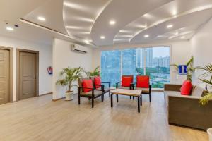 an office lobby with red chairs and a table at Townhouse Sector Near Logix city centre in Noida