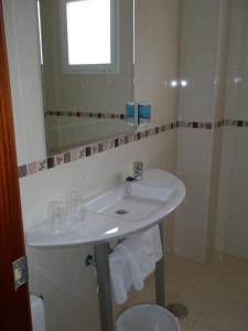y baño con lavabo blanco y espejo. en Hotel Mayna, en Benidorm