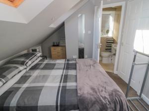a bedroom with a bed and a bathroom at The Apartment in Longframlington