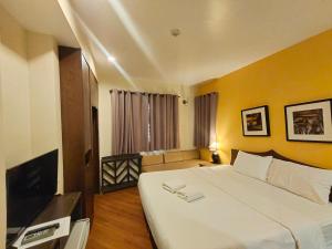 um quarto com uma cama grande e uma televisão em Vinary Hotel Sukhumvit - SHA EXTRA Plus em Bangkok