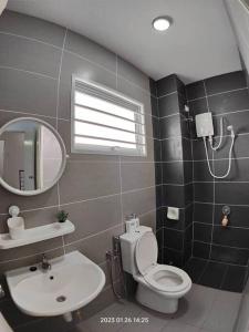 a bathroom with a toilet and a sink and a mirror at Prima Guest House - Puncak Alam Homestay Mus-lim friendly in Bandar Puncak Alam