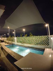 una piscina en un edificio por la noche en Prima Guest House - Puncak Alam Homestay Mus-lim friendly en Bandar Puncak Alam