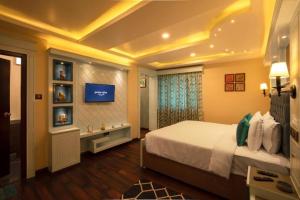 a bedroom with a large bed and a tv at Heritage View in Ooty