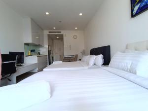 2 weiße Betten in einem Zimmer mit Küche in der Unterkunft RM020 Bukit Bintang 118 Tower Balcony View in Kuala Lumpur