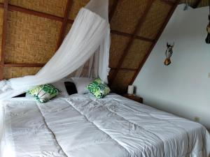 1 dormitorio con 1 cama con mosquitera en Magical Breeze Cabin, en Angsri