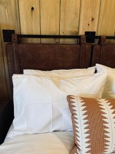 a bed with white pillows and a wooden headboard at The Tangerine Motel 